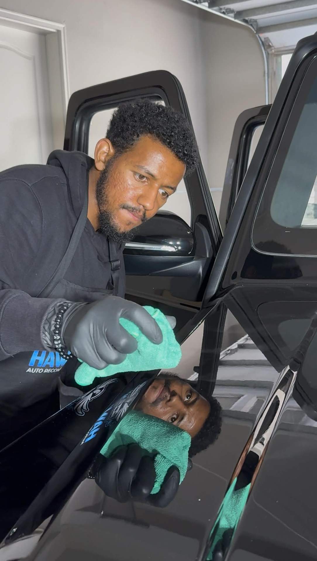 Hawks Auto Protection technician hand-finishing a luxury SUV